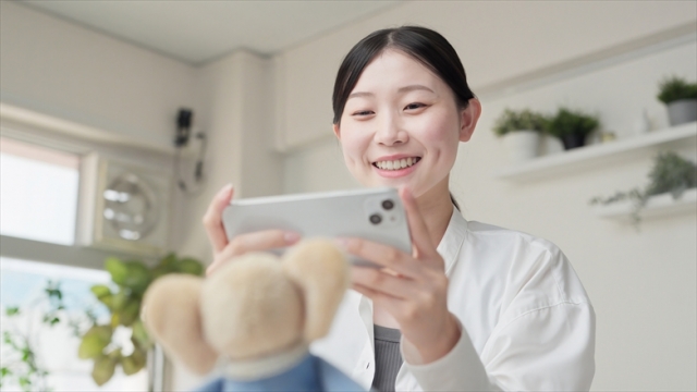 メルカリで出品するため写メを撮る女性