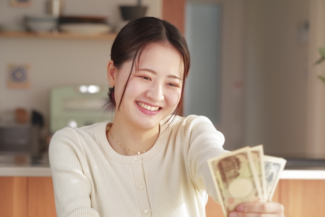メルカリで不用品販売し稼いだお金を眺める女性